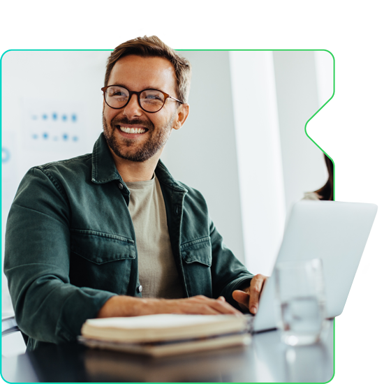 Man smiling while working on a computer