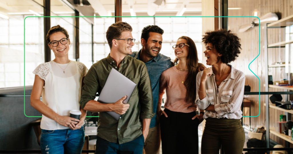 eine Gruppe von Kollegen, die lächelnd ein Gerät der Marke synergy learning im Rücken haben